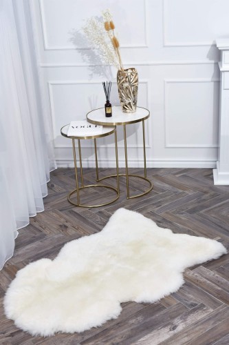 Soft and fluffy natural sheepskin rug in cream colour.