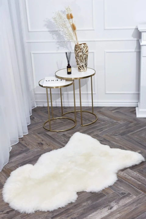 Soft and fluffy natural sheepskin rug in cream colour.